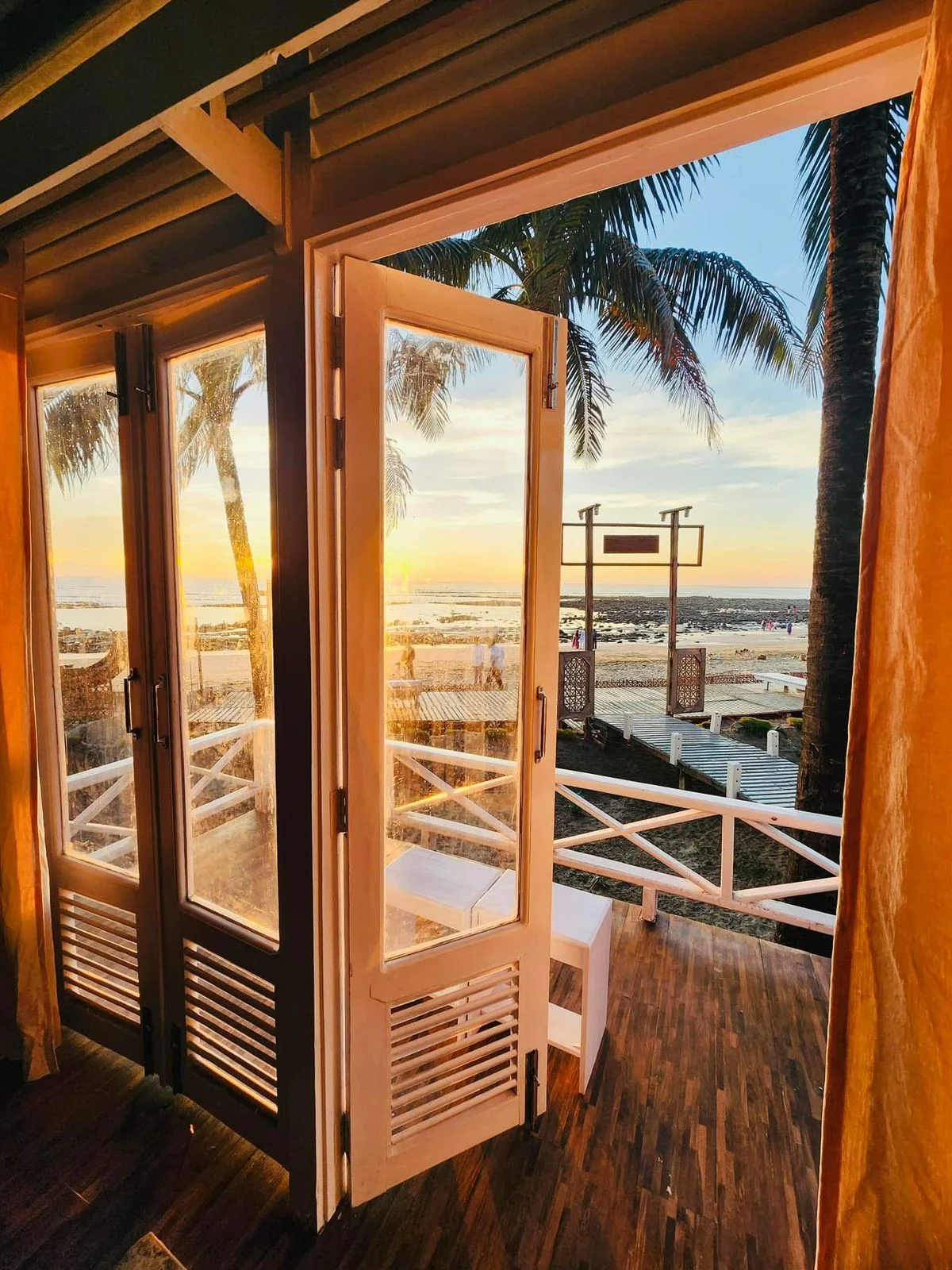 Golden sunset seen through the open doors of a sea-view villa